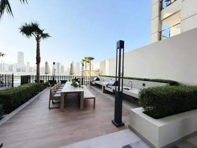 a patio with a table and benches on a building at Belgravia Heights II 1 BHK in JVC Luxury Living in Dubai