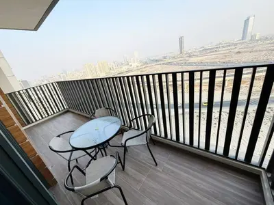 a balcony with a table and chairs on a balcony at Belgravia Heights II 1 BHK in JVC Luxury Living in Dubai