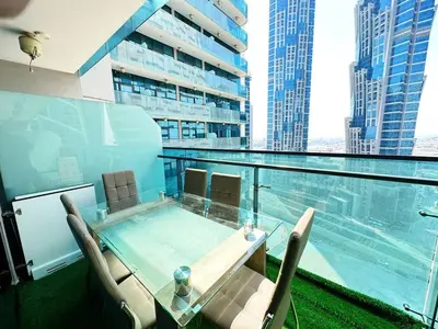 a balcony with a glass table and chairs on a building at Merano Tower 1BHK in Business Bay By Petals Holiday Homes in Dubai