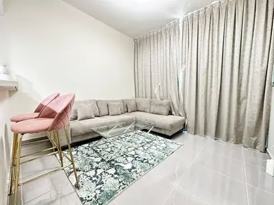 a living room with a couch and a pink chair at Merano Tower 1BHK in Business Bay By Petals Holiday Homes in Dubai