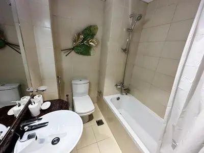 a bathroom with a sink and a toilet and a tub at Comfortable Studio Retreat in Dubai Sports City in Dubai