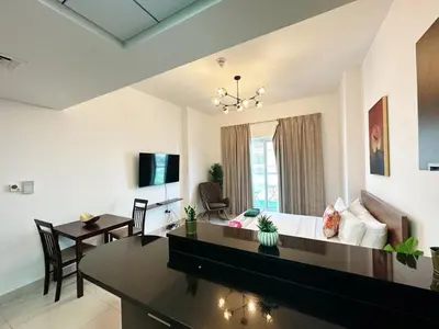a living room with a couch and a table at Comfortable Studio Retreat in Dubai Sports City in Dubai