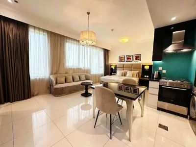 a kitchen and living room with a table and a couch at Capital Bay Studio in Business Bay by Petals Holiday Homes in Dubai