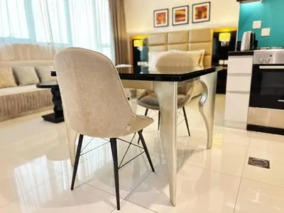 a dining table and chairs in a living room at Capital Bay Studio in Business Bay by Petals Holiday Homes in Dubai