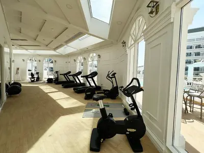 a gym with a row of treadmills and exercise bikes at Vincitore Benessere 1BHK in Arjan by Petals Holiday Homes in Dubai