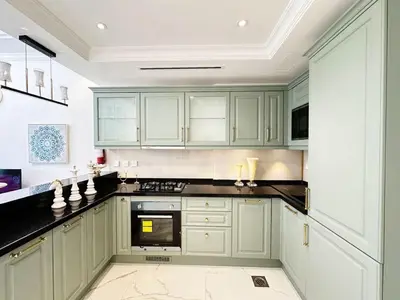 a kitchen with green cabinets and a black counter top at Vincitore Benessere 1BHK in Arjan by Petals Holiday Homes in Dubai