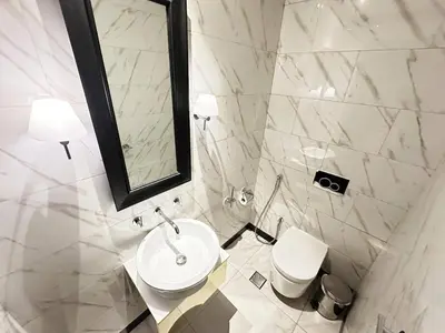 a white bathroom with a toilet and a mirror at Elegant 1BR in Business Bay in Dubai