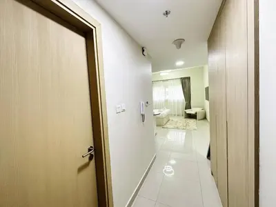 a bathroom with a door leading to a toilet at Profile Residency Studio near Dubai Stadium by Petals Holiday Homes in Dubai