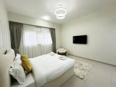 a bedroom with a bed and a tv in it at Profile Residency Studio near Dubai Stadium by Petals Holiday Homes in Dubai