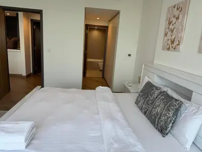 a bedroom with a large white bed with two pillows at 1 Residence 1BHK near Metro by Petals Holiday Homes in Dubai
