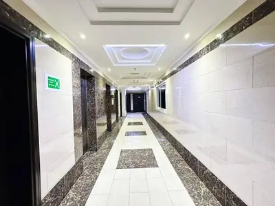 a corridor in a building with white tile walls and a hallway at Cordoba Palace Studio In Silicon Oasis by Petals Holiday Homes in Dubai