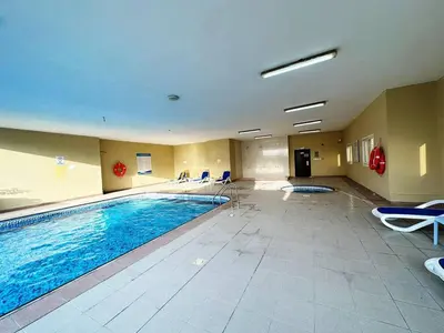 a large swimming pool in a hotel room at Cordoba Palace Studio In Silicon Oasis by Petals Holiday Homes in Dubai