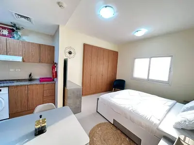 a small bedroom with a bed and a kitchen at Cordoba Palace Studio In Silicon Oasis by Petals Holiday Homes in Dubai