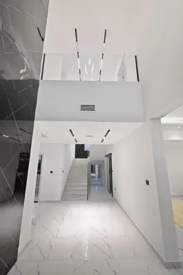 a white hallway with stairs in a building at 5 BR Villa Near Business Bay By Petals Holiday Homes in Dubai