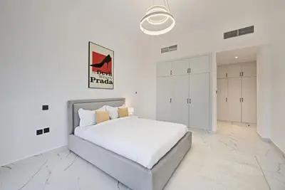 a white bedroom with a large white bed in it at 5 BR Villa Near Business Bay By Petals Holiday Homes in Dubai