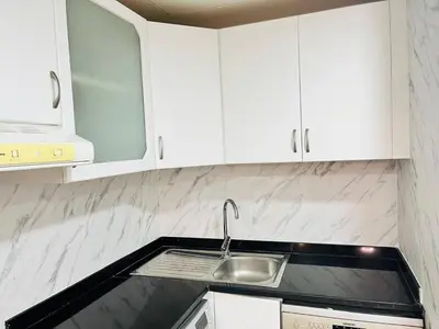 a kitchen with white cabinets and a sink at Indigo Tower 1 BR in JLT by Petals Holiday Homes in Dubai