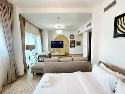 a living room with a bed and a couch and a television at preatoni tower 1 BHK in JLT By petals Holiday Homes in Dubai
