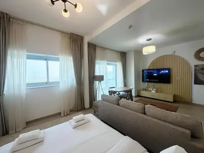a living room with a couch and a tv in a room at preatoni tower 1 BHK in JLT By petals Holiday Homes in Dubai