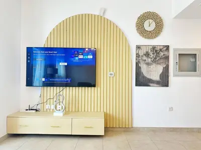 a living room with a flat screen tv on a wall at preatoni tower 1 BHK in JLT By petals Holiday Homes in Dubai