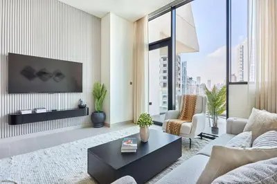 a living room with a couch and a tv at Frank Porter - Binghatti Phantom in Dubai