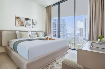 a white bedroom with a large bed and a large window at Frank Porter - Binghatti Phantom in Dubai