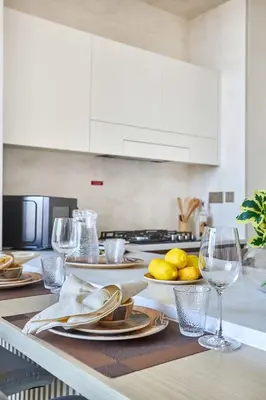 a kitchen with a table with plates and wine glasses at Frank Porter - Binghatti Phantom in Dubai