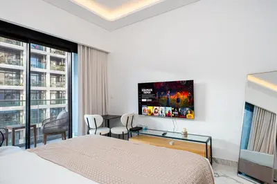a bedroom with a bed and a tv on the wall at Modern Std Near Burj Khalifa with Pool and City Views in Dubai