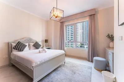 a bedroom with a bed and a large window at HAVN - 2 Bed in The Residences, Burj Khalifa View in Dubai