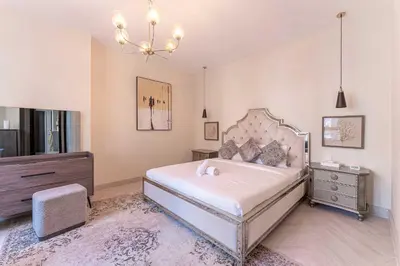 a bedroom with a large bed and a chandelier at HAVN - 2 Bed in The Residences, Burj Khalifa View in Dubai