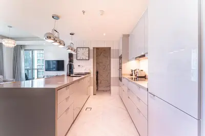 a kitchen with white cabinets and a large island at HAVN - 2 Bed in The Residences, Burj Khalifa View in Dubai