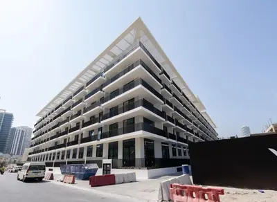a large building in a city with a parking lot at Binghatti Aurora Soft-Luxe 1BR Abode w Gym & Pool in Dubai