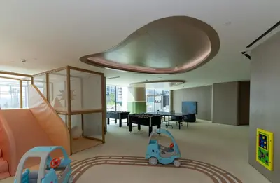 a living room with a slide and a dining room at Luxury 1BR in JVC Private Balcony Pool & Parking in Dubai