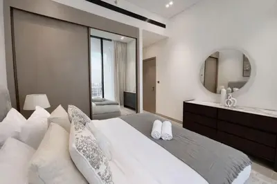 a bedroom with a large white bed and a mirror at Urban Oasis 1BR W Private Plunge Pool in Dubai
