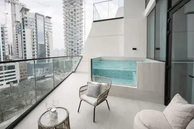 a balcony with a swimming pool and a chair at Urban Oasis 1BR W Private Plunge Pool in Dubai