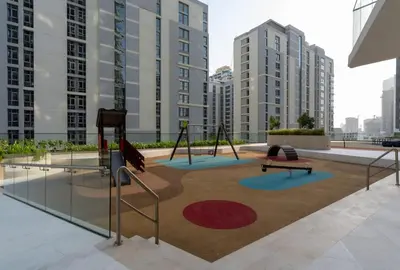 a playground in the middle of a city with tall buildings at Urban Oasis 1BR W Private Plunge Pool in Dubai
