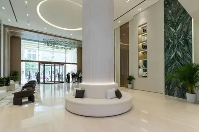 a lobby with a white column in a building at Stylish Escape 1BR Plunge Pool & Pool View in Dubai