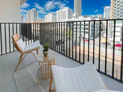 a balcony with two chairs and a table at Warm Modern 1BR Haven with Balcony & Free Parking in Dubai