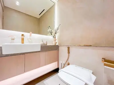 a bathroom with a sink and a toilet and a mirror at Warm Modern 1BR Haven with Balcony & Free Parking in Dubai