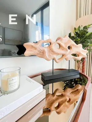 a table with a candle and some books on it at Warm Modern 1BR Haven with Balcony & Free Parking in Dubai