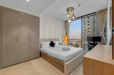 a bedroom with a bed and a large window at Waves - Elegant High-Floor 2BR Close To Downtown in Dubai