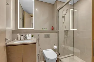 a bathroom with a shower and a toilet and a sink at Waves - Elegant High-Floor 2BR Close To Downtown in Dubai