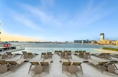 a group of chairs sitting on a patio next to a body of water at Luxury one bed flat in Dubai Harbour in Dubai