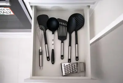 a cupboard filled with spatulas and utensils at Luxury one bed flat in Dubai Harbour in Dubai