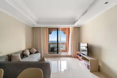 a living room with a couch and a television at 2BHK in Palm Jumeirah Sea View Grandeur Residence 301 in Dubai