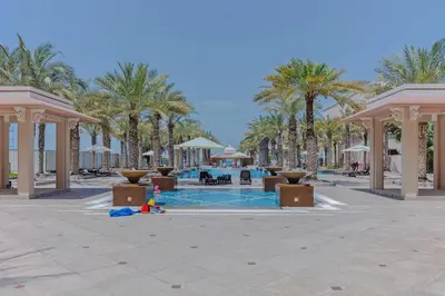 a resort with a swimming pool and palm trees at 2BHK in Palm Jumeirah Sea View Grandeur Residence 301 in Dubai