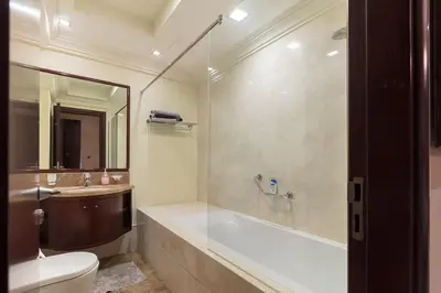 a bathroom with a tub and a toilet and a sink at 2BHK in Palm Jumeirah Sea View Grandeur Residence 301 in Dubai