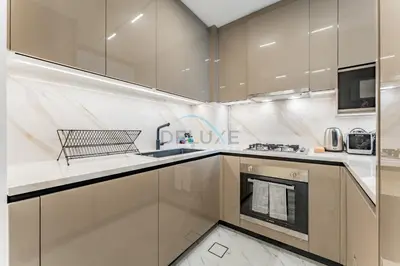 a kitchen with white cabinets and a sink at Community View 1BR, Perfectly Located Near the Park, Just a Short Drive Away from Dubai Top Tourist Attractions, Adhara Star, Arjan by Deluxe Holiday Homes in Dubai