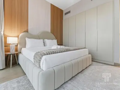 a bedroom with a large white bed with a couch at Brand New 2 Bed Contemporary Apt-Gym Pool Access in Dubai