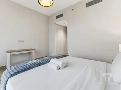 a bedroom with a white bed with towels on it at Brand New 2 Bed Contemporary Apt-Gym Pool Access in Dubai