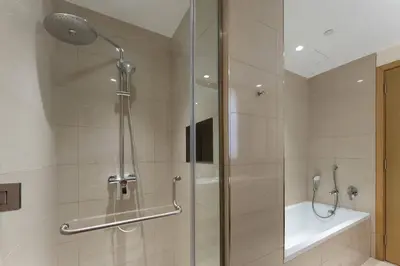 a shower with a glass door in a bathroom at PVH - Acacia C - Spacious 1BR with Direct Dubai Hills Park Access in Dubai